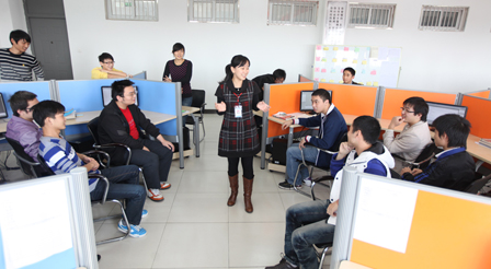 導(dǎo)師在企業(yè)環(huán)境下的實訓(xùn)室內(nèi)給學(xué)生們上課